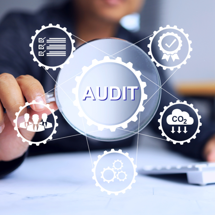 A person holding a magnifying glass over a central 'AUDIT' icon, surrounded by six white gear-shaped icons with business and environmental symbols on a blurred office background.