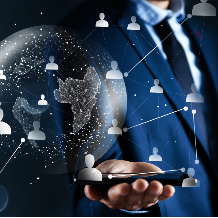 A man in a blue suit holds a smartphone with a glowing digital globe and network of connected user icons overlaid, suggesting global connectivity or business technology.