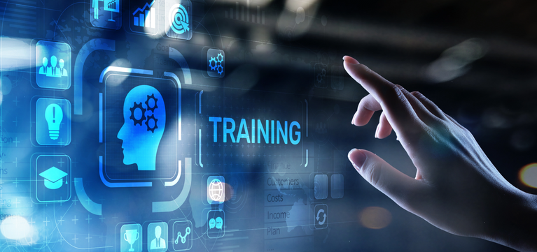 A futuristic digital interface with glowing blue icons and the word TRAINING, with a human hand reaching toward the screen in a dim, blurred environment.